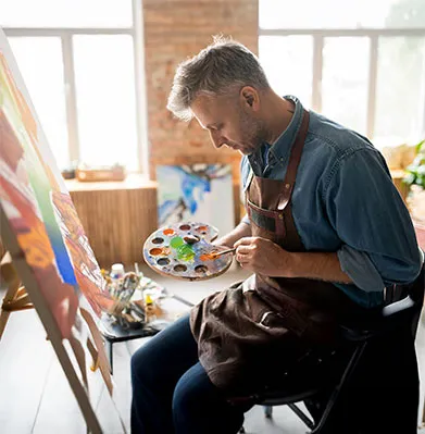Photo: Man painting on canvas